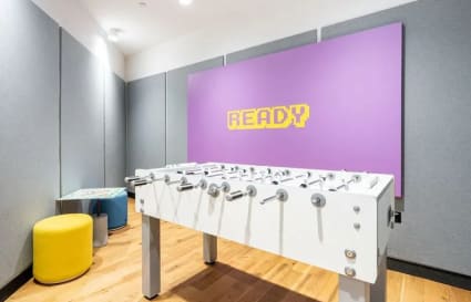 Vibrant game room with foosball table and colorful decor in a flexible coworking space on Robinson Road.