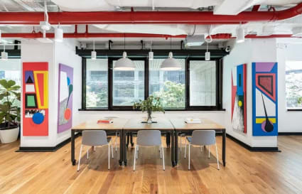 Bright coworking area with modern art, natural light, and stylish seating on Robinson Road.