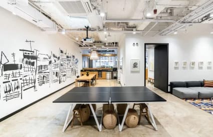 Dynamic coworking space with open layout, creative wall art, and communal amenities in Cross Street.