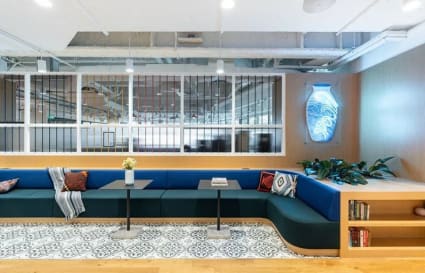 Bright, modern coworking lounge with cozy seating, vibrant decor, and ample natural light.
