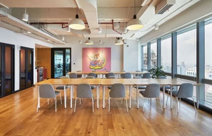 Modern coworking space with abundant natural light and a vibrant, artistic flair.