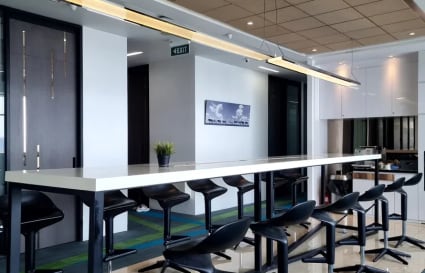 Modern coworking area with sleek high tables and stools, ideal for collaborative work.