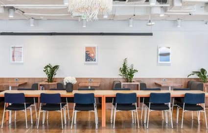 Modern coworking space on Ayala Ave. features communal tables, vibrant chairs, and greenery.