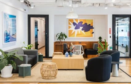 Inviting coworking lounge with modern decor and ample natural light in a prime location.