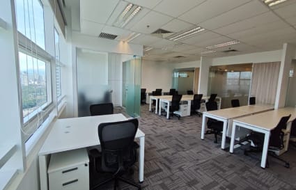 Modern coworking space with abundant natural light and versatile workstations in Jalan Stesen.