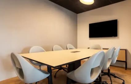 Sleek meeting room with modern seating and a large screen, perfect for collaborative sessions.