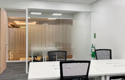 Modern coworking space with sleek desks, ergonomic chairs, and abundant natural light.