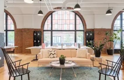 Modern coworking space with natural light, stylish seating, and bright, open layout.