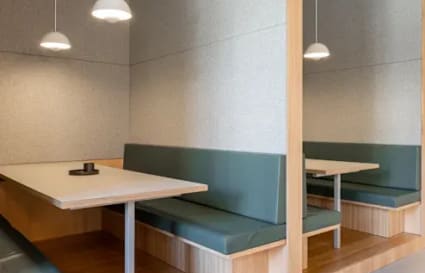 Modern coworking space with cozy booths, sleek lighting, and versatile seating in Raipur.