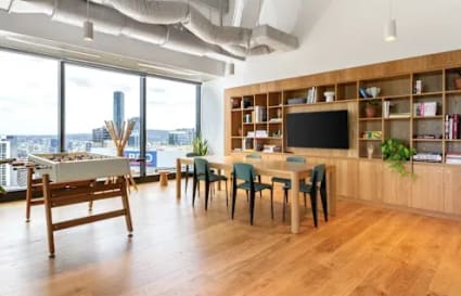 Modern coworking space with panoramic views, ample seating, and built-in bookshelves.