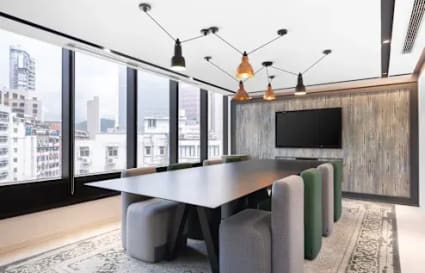 Modern conference room with city views, stylish lighting, and a large screen for presentations.