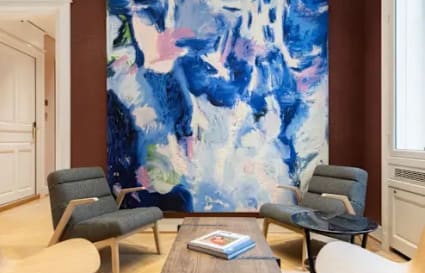 Cozy lounge area with stylish chairs, vibrant artwork, and natural light, ideal for collaboration.