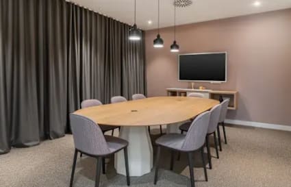 Sleek meeting room with a modern table, plush seating, and ambient lighting perfect for collaboration.