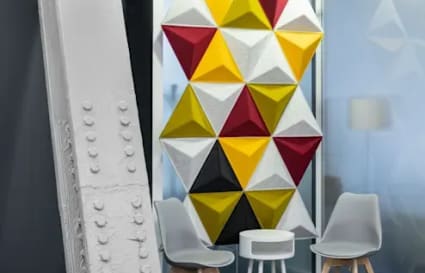 Modern coworking space with stylish seating, vibrant geometric wall art, and a bright ambiance.