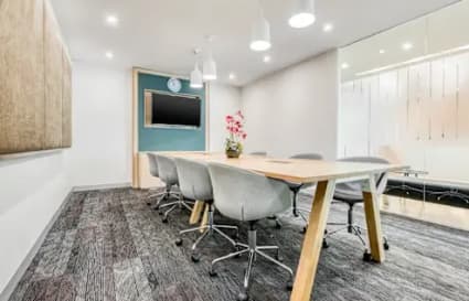Modern coworking space with sleek design, ample lighting, and a collaborative meeting area.