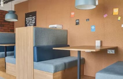 Modern coworking booths with cushioned seating and warm lighting in Hyderabad.