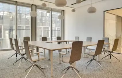Modern coworking space with ample natural light and sleek, comfortable seating.