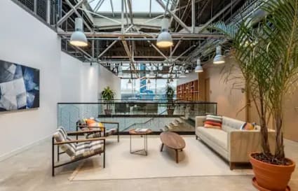 Modern coworking space with natural light, cozy seating, and vibrant plant decor in Kondapur.