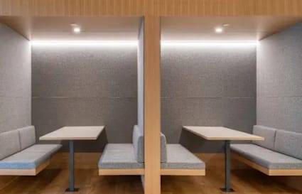 Modern coworking booths with sleek seating and soft lighting, perfect for focused work.