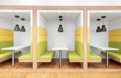 Modern coworking booths with vibrant seating and individual lighting on Neco Garden Road.