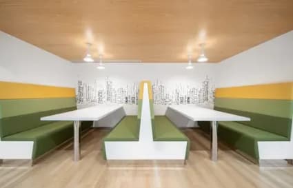 Modern coworking space in Vadodara with vibrant booth seating and skyline artwork.
