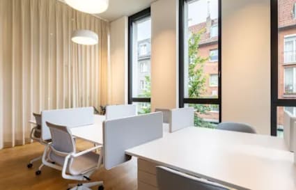 Bright coworking space with modern desks, ergonomic chairs, and large windows for natural light.