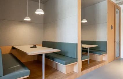 Elegant coworking booths with plush seating and modern pendant lighting on Sahar Road.