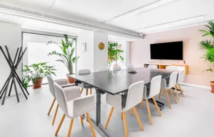 Bright and modern coworking space with a sleek conference table and abundant natural light.