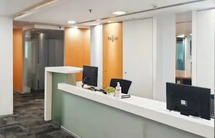 Modern coworking space with sleek desks, ample lighting, and a welcoming reception area.
