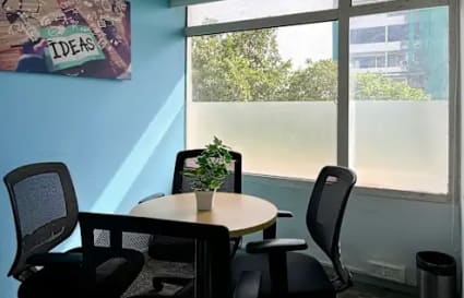 Bright coworking space with natural light, modern chairs, and a collaborative vibe.