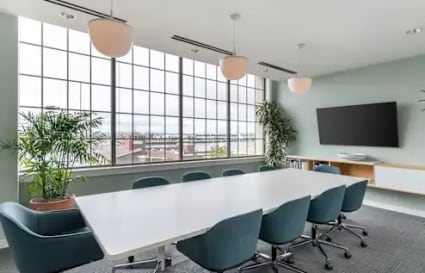 Bright meeting room with modern furnishings and large windows offering ample natural light.