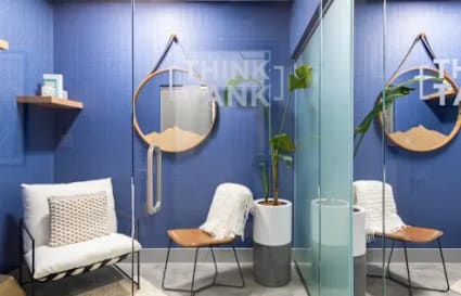 Modern coworking space with cozy chairs, stylish decor, and a calming blue palette.