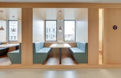Modern coworking nook with ample natural light and cozy seating, ideal for collaboration.