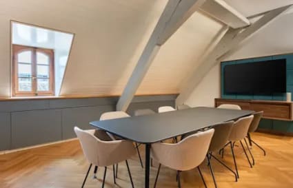 Modern coworking meeting room with sleek table, comfy chairs, and natural light in Lazer Street.