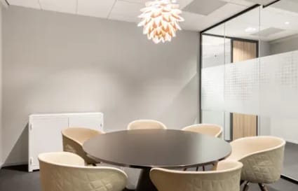 Stylish meeting room with modern chandelier and comfortable seating in a coworking space.