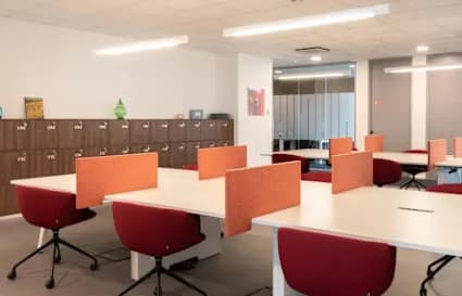 Modern coworking space with shared desks, comfortable seating, and vibrant decor.