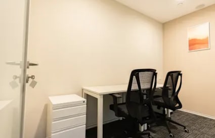 Modern coworking space with ergonomic chairs and ample natural light, ideal for productivity.