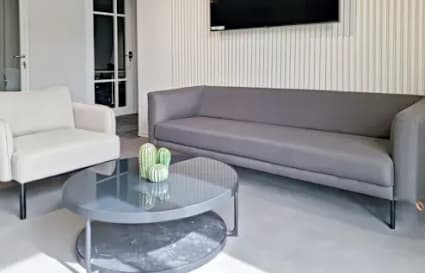 Stylish lounge area with modern seating and a sleek coffee table, perfect for a relaxed work session.