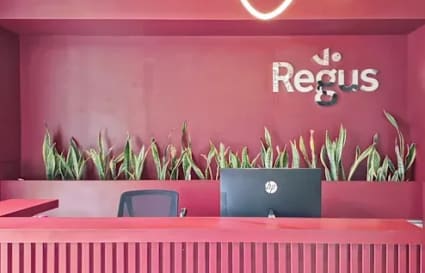 Modern reception area with bold red design and sleek lighting at a flexible coworking space.