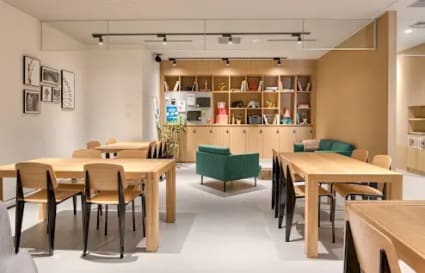 Modern coworking space with versatile seating, natural wood tables, and inviting lounge area.