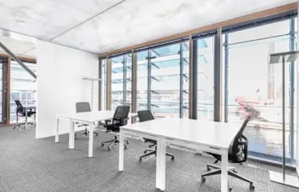 Bright coworking space with modern desks and ergonomic chairs, overlooking scenic views.