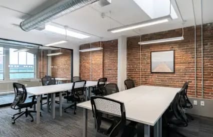 Modern coworking space with exposed brick, natural light, and ergonomic seating in Navi Mumbai.