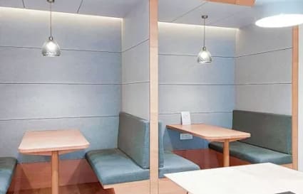 Modern coworking booths with cozy seating and stylish pendant lighting in Powai.