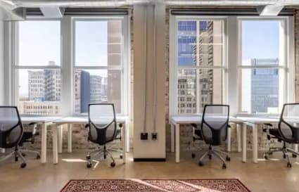 Bright coworking space with modern desks, ergonomic chairs, and stunning city views.