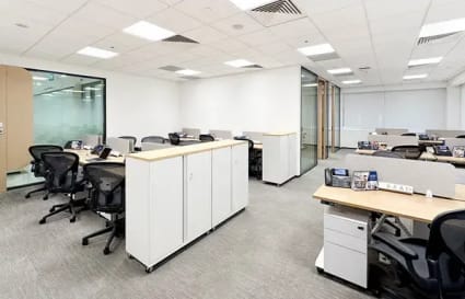 Modern coworking space with open desks, natural light, and sleek furnishings in Raffles Place.