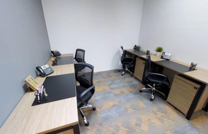 Modern coworking space with ergonomic chairs, ample desk space, and neutral decor.