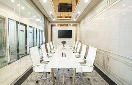 Elegant boardroom with sleek white chairs, modern table, and integrated AV setup. Perfect for meetings.