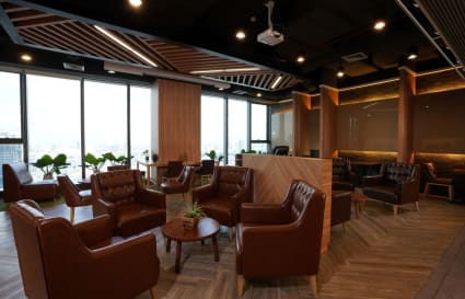Modern coworking space with plush leather seating and city views on Rama IX Road.
