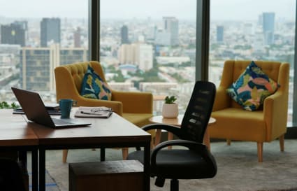 Bright coworking space with city views, modern furniture, and vibrant decor. Ideal for productivity.