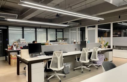 Modern coworking space with sleek desks, ergonomic chairs, and abundant natural light.